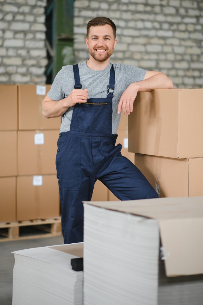 Warehouse worker carrying a carton for delivery to production stock.